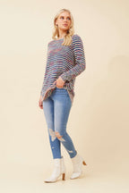 Stylish model wearing the Sunniva Multi Knit jumper, paired with ripped jeans and ankle boots for a chic look.