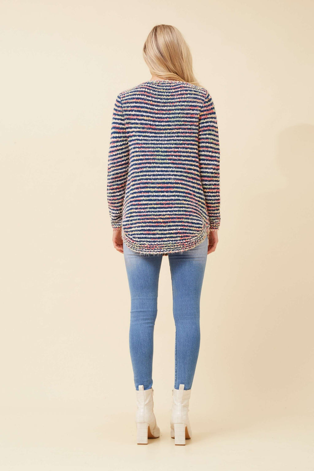 Model showcasing the back of the Sunniva Multi Knit jumper, featuring a colorful striped design and casual style.