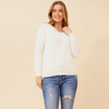 Rochelle Pearly Jumper styled with ripped jeans, featuring pearl button details and a cozy fabric.