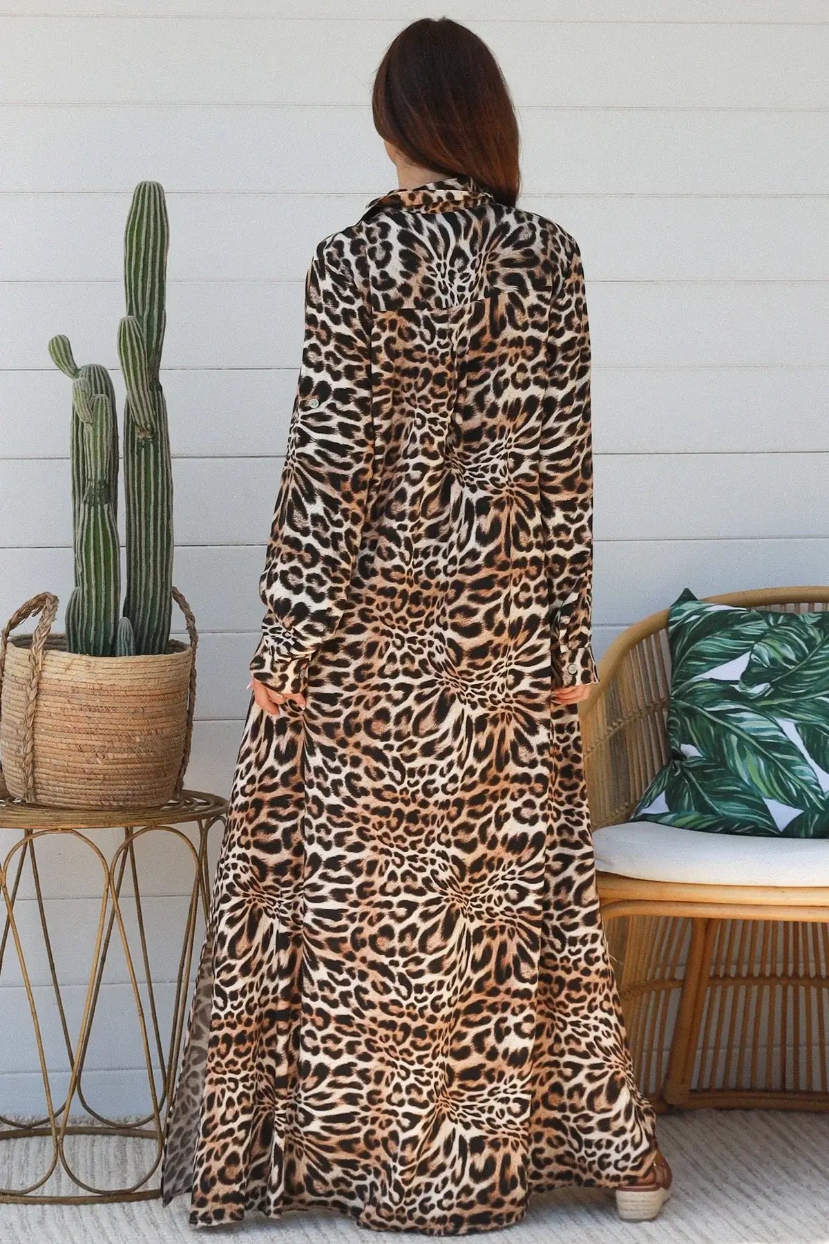 Back view of a woman wearing a Leopard Maxi Shirt Dress in a chic setting, showcasing its bold leopard print.