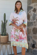 Model wearing the Isabella Shirt Dress with palm tree print, showcasing a relaxed coastal style perfect for warm weather.
