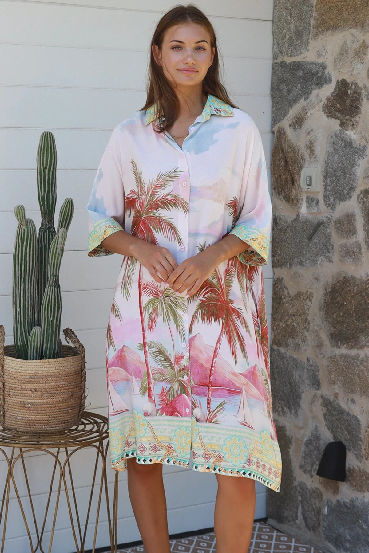 Model wearing the Isabella Shirt Dress with palm tree print, showcasing a relaxed coastal style perfect for warm weather.