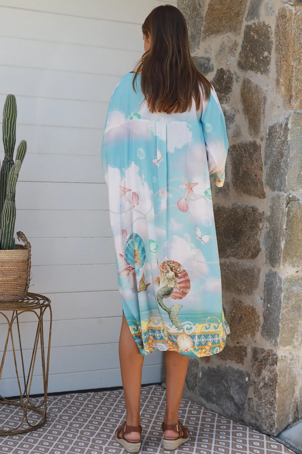 Woman wearing a Cameron Shirt Dress with a colorful beach print, showcasing a relaxed fit and stylish design.