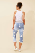 Back view of a model wearing CKM 7/8 Star Jogger Pants with a star print in light denim.