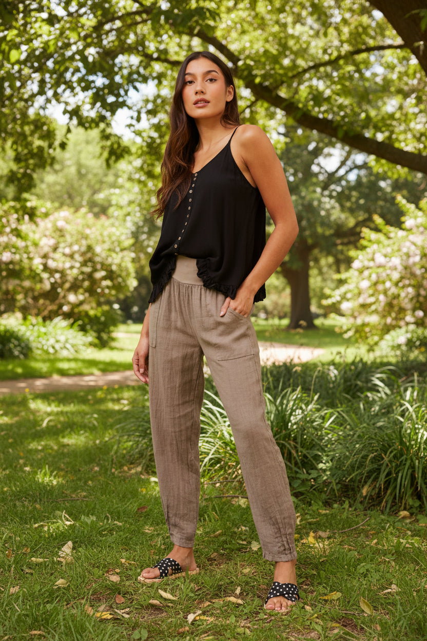 Model wearing Roma Linen Pants in a sunny park, showcasing Italian craftsmanship and relaxed elegance.