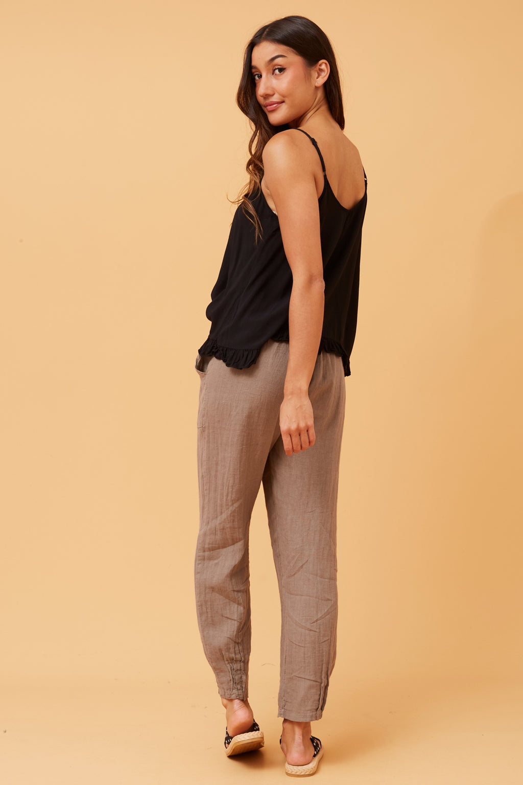 Model showcasing the Roma Linen Pants by Bottega Moda with a stylish black top and relaxed pose.