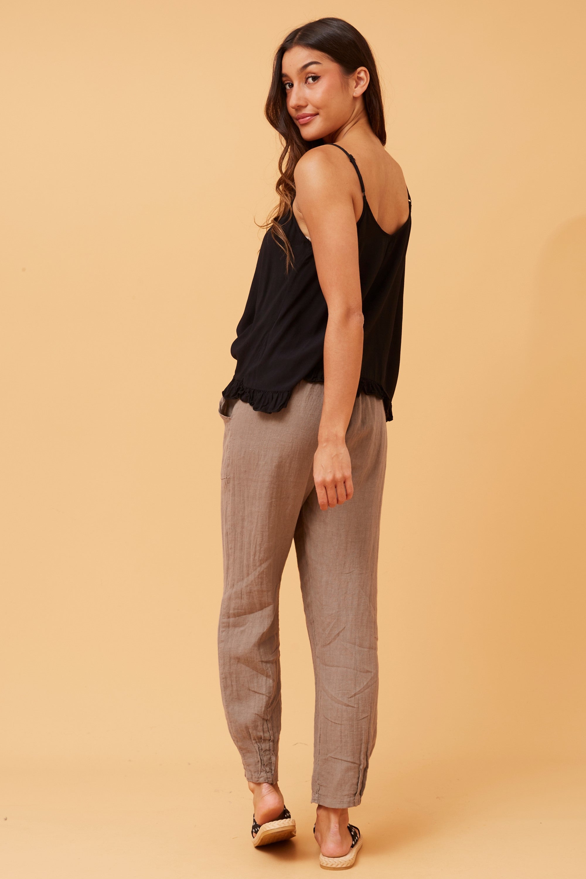 Model showcasing the Roma Linen Pants by Bottega Moda with a stylish black top and relaxed pose.