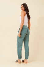 Model wearing Roma Linen Pants from behind, showcasing the relaxed fit and elastic waistband.