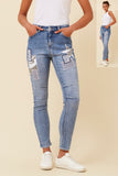 Stylish model wearing Patch Jeans with front and back pockets, denim fabric, and adjustable waistband.