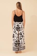 Back view of a woman wearing Bahama Pants with a black top, showcasing the bold black print on a cream base.