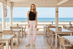 Model wearing Ronja Wide Leg Jeans in nougat shade, showcasing relaxed fit in a beachside setting.