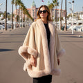 Model wearing a Lux Fur Trim Cape with plush faux fur detailing, perfect for elegant layering.