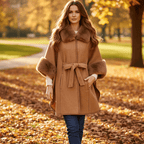 Woman in a park wearing the Anya Cape with faux fur trim, showcasing its stylish design and cozy fit.