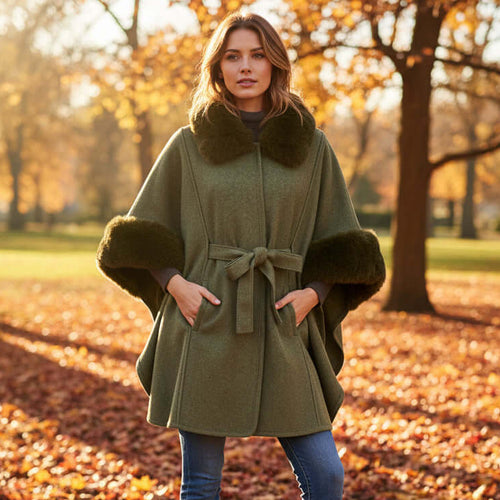 Anya Cape in a stylish outdoor setting, featuring faux fur trim and a chic belt tie for a flattering look.