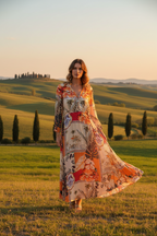 A model wearing the Sri Palm 3 Button Dress, showcasing its elegant design against a scenic countryside backdrop.