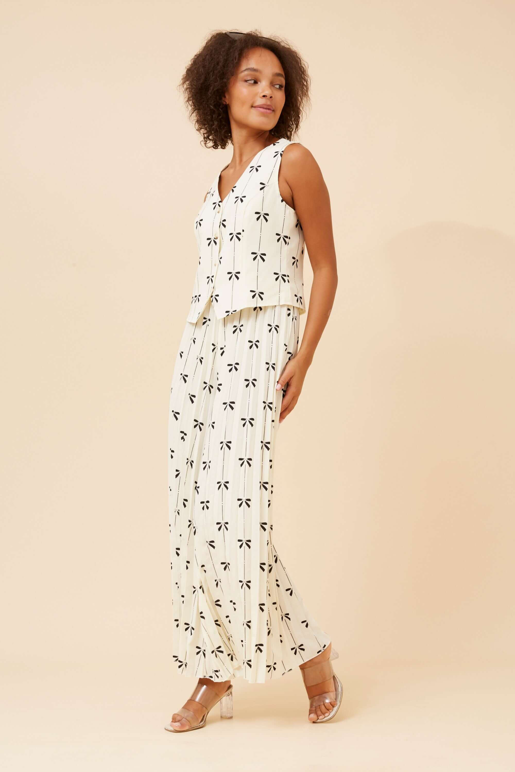 Maja Bows Pant Set featuring a sleeveless top and wide leg pleated pants with black bow print on a chic ivory background.