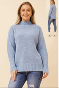 Model wearing a stylish High Neck Pullover in soft blue, featuring side splits and cozy knit.