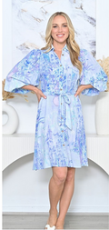 A model wearing an Iris Shirt Dress with collar, button down front, and tie belt, showcasing a stylish floral pattern.