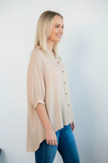 Model wearing QQ Bishop Blouse white in relaxed fit with button details and mandarin collar, showcasing a stylish side view.