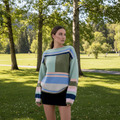 Model wearing Maja Multi Jumper against a snowy mountain backdrop, showcasing its vibrant colors and relaxed fit.