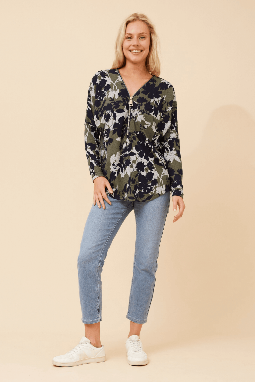 Model wearing a floral Valery Zip Top paired with jeans, showcasing relaxed elegance and style.