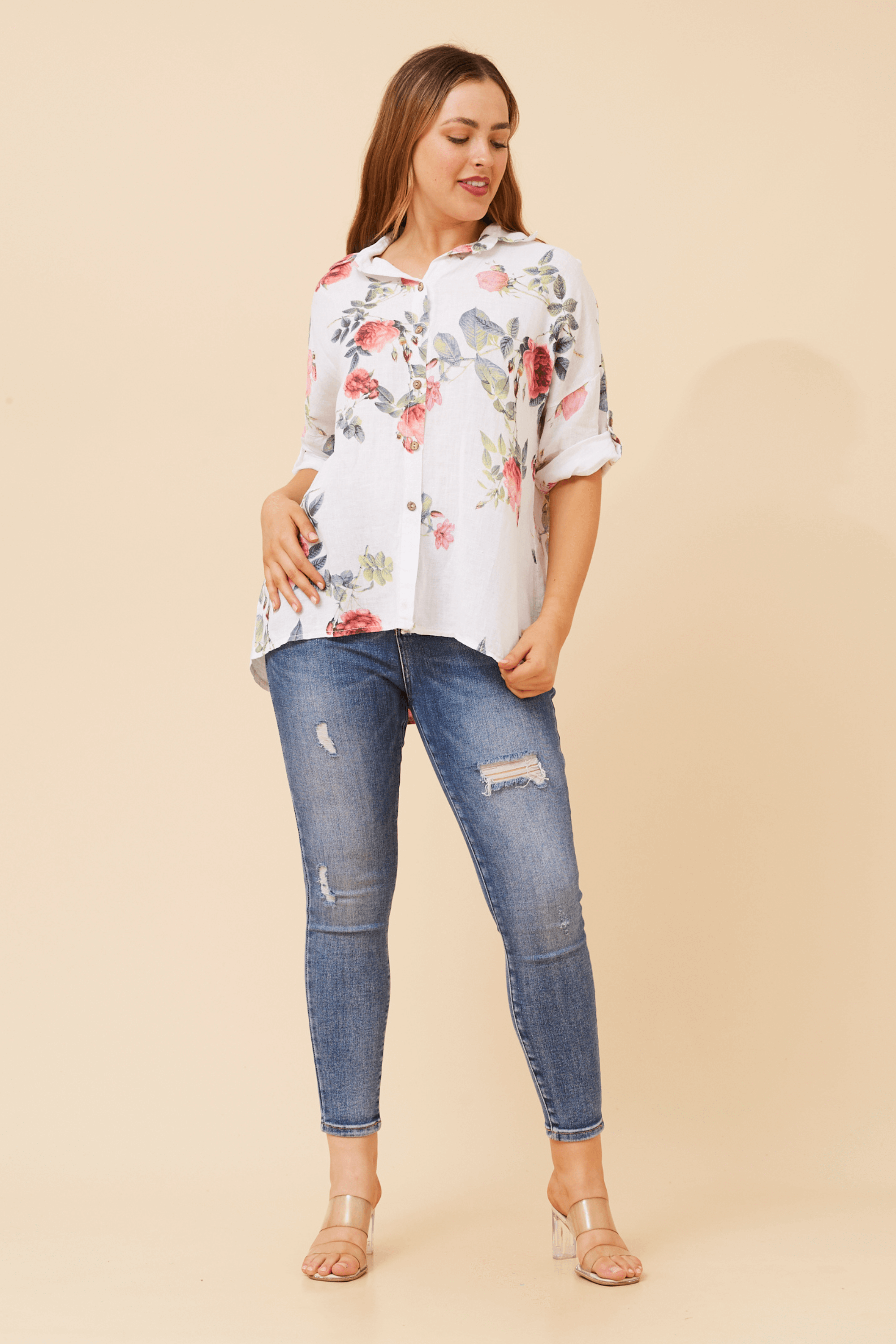 Eira Roll up sleeve shirt displayed with floral design paired with denim jeans on a model