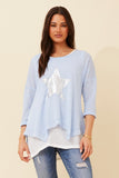 Woman wearing the Charity Star Top featuring a star print and sequins, perfect for a stylish casual look.