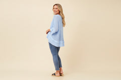 Woman wearing aMesh Net Top in light blue color with 3/4 sleeves and raw edging, paired with denim jeans.