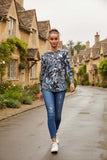 Model wearing Matilde Crew Neck Top with floral print walking down a charming street.