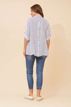 Back view of a woman wearing the Alma Striped Shirt with navy and white stripes, showcasing its hi-lo hem and 3/4 roll-up sleeves.