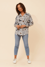 Woman wearing Leonor Cat Zip Top featuring a cute cat print, styled with relaxed jeans and sneakers.