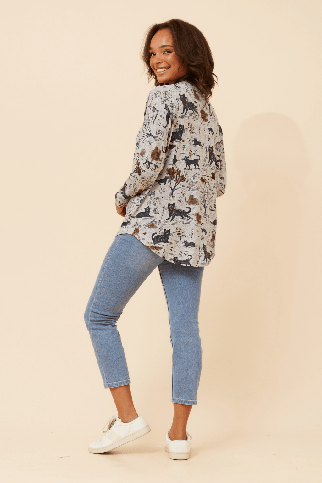 Woman wearing the Leonor Cat Zip Top featuring a playful cat print and a stylish relaxed fit.