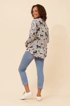 Woman wearing the Leonor Cat Zip Top featuring a playful cat print and a stylish relaxed fit.