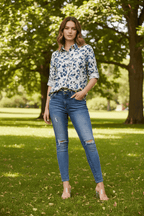 Model wearing the Zola Leopard Shirt with skinny jeans in a lush park setting, showcasing stylish elegance.