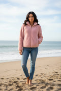 Model wearing a cozy Teddy Jacket on the beach, showcasing plush fleece and stylish design.