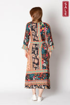 Back view of Gisele Midi dress with flared cuffs, colorful floral patterns, and optional waist tie, displayed on a model.