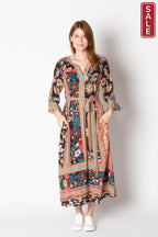 Model wearing the Gisele Midi dress featuring floral patterns and flared cuffs, showcasing pockets.