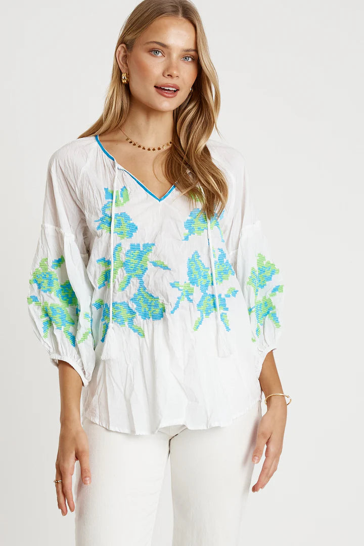 Model wearing the LulaLife Rosalind Top White featuring colorful embroidery and relaxed fit with scooped neckline.