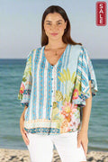 Model wearing Bahama Flutter Top Lagoon by Lulasoul, showcasing vibrant colors and flutter sleeves.