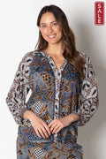 Woman wearing the Bilboa Top Multi, showcasing its luxurious design and 3/4 length sleeves with vibrant prints.