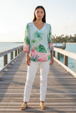 Model wearing the Bora Bora Top on a scenic boardwalk, showcasing island vibes with palm tree designs.