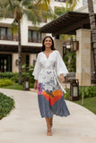 Model showcasing Byron Midi Lulasoul dress with artistic prints and high-low hem in a tropical setting.