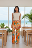 Model wearing vibrant Quintana Pants with floral print, perfect for summer style and beach outings.