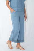 Model wearing Pari Linen Pants in soft blue, showcasing relaxed fit and premium linen texture.