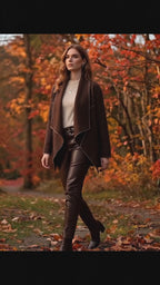 Model wearing WL Zita Coat, walking through autumn scenery with vibrant fall leaves.
