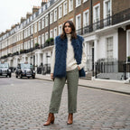 Model wearing Mongolian Vest with faux fur on city street, styled with a cozy sweater and chic pants.
