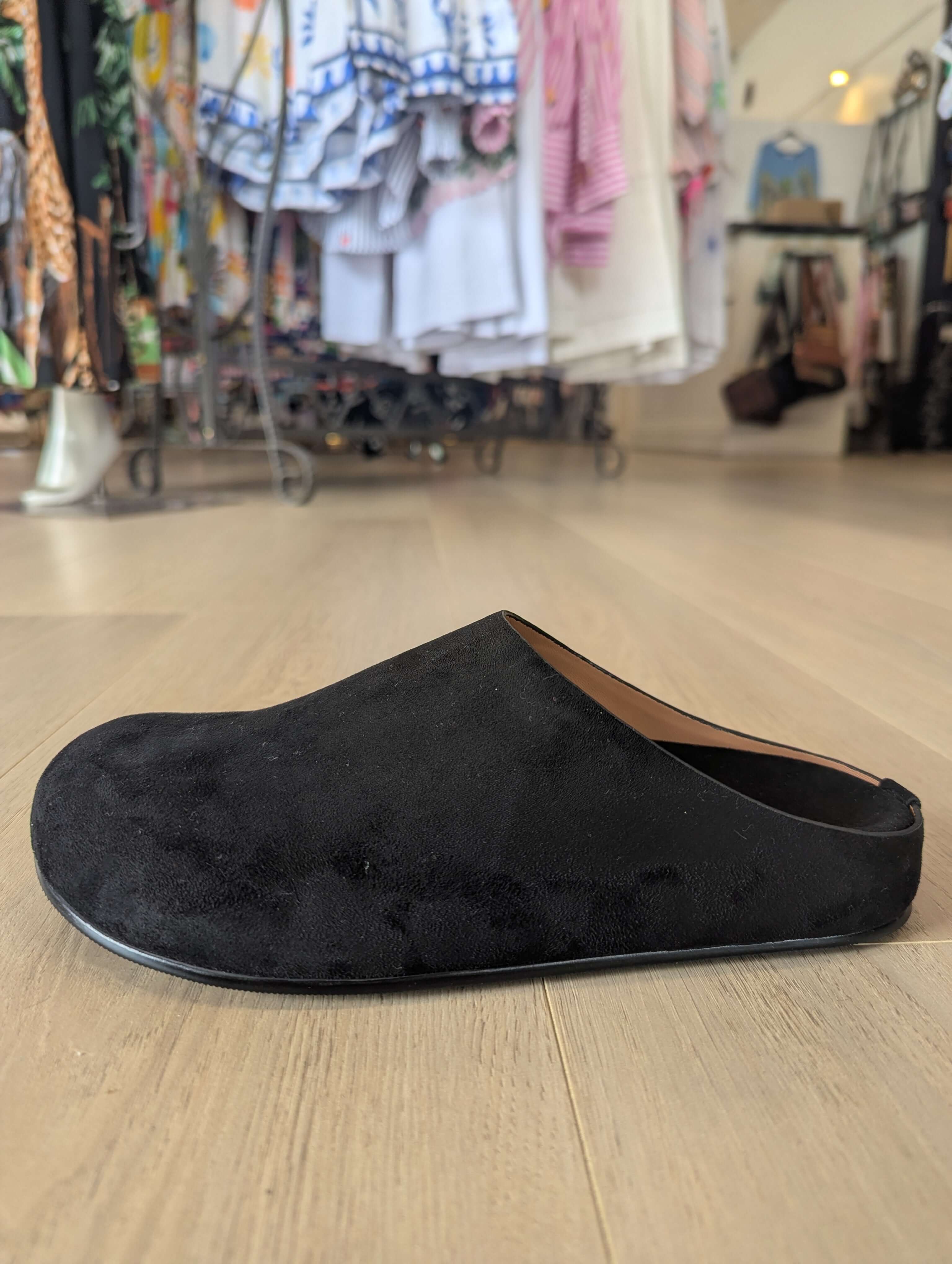 Los Cabos Lumi Slides featuring a black synthetic suede upper displayed in a retail setting.