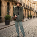 Woman wearing a stylish Mongolian Vest with hat and green pants in a charming street setting.