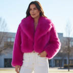 Chloe Faux Fur Jacket in vibrant pink worn with stylish white pants, showcasing a bold collar and luxurious faux fur.