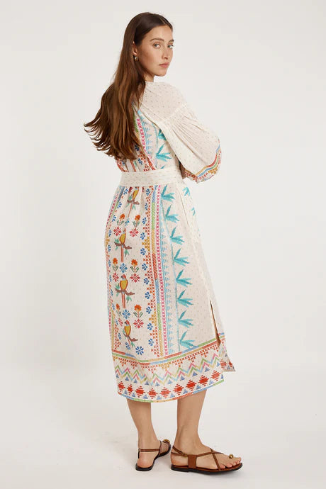 A model showcases the Biscay Maxi White dress, featuring vibrant embroidery, a flattering fit, and a relaxing vibe.